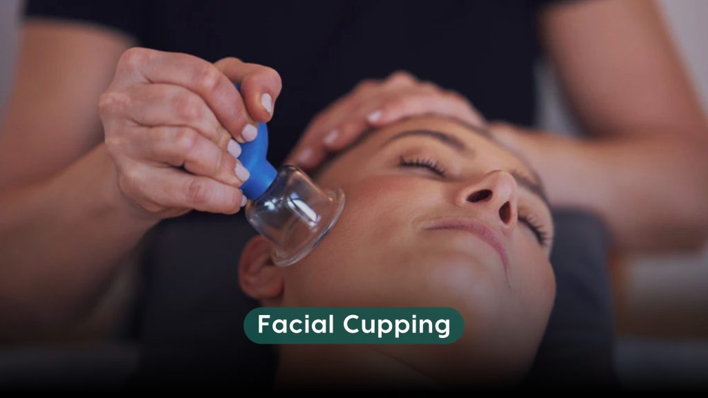Therapist performing facial cupping therapy on a woman’s face using a small suction cup for skin rejuvenation.